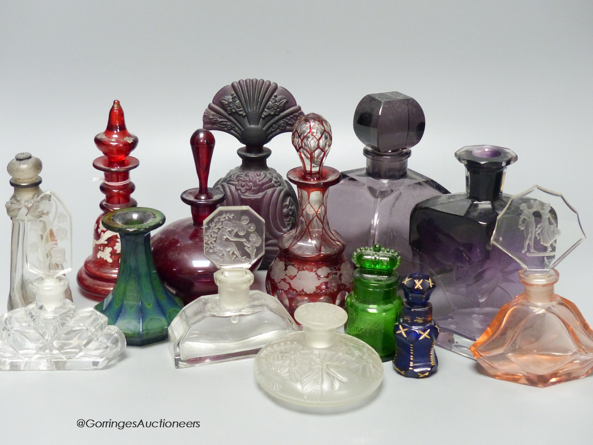 A collection of 1920's and earlier glass scent bottles to include ruby, amethyst, blue, clear and green